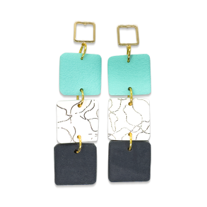 Contemporary cube shaped dangly earring in mint green, patterned white and black and textured black. With cubed gold stud